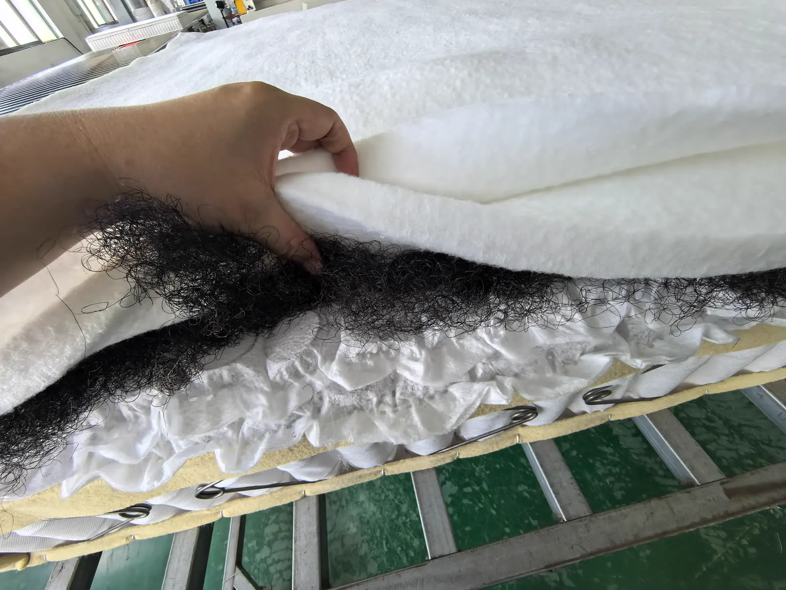 Visible layers at the edge of a mattress in an existing Sipu production photograph